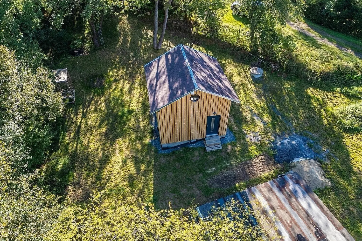 Letecký pohled na dřevostavbu se sedlovou střechou uprostřed zahrady